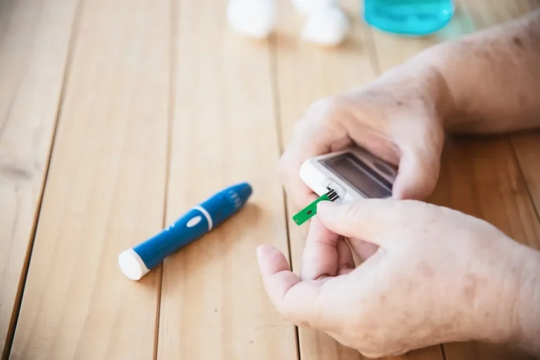 Old Lady is testing blood sugar level using test kit