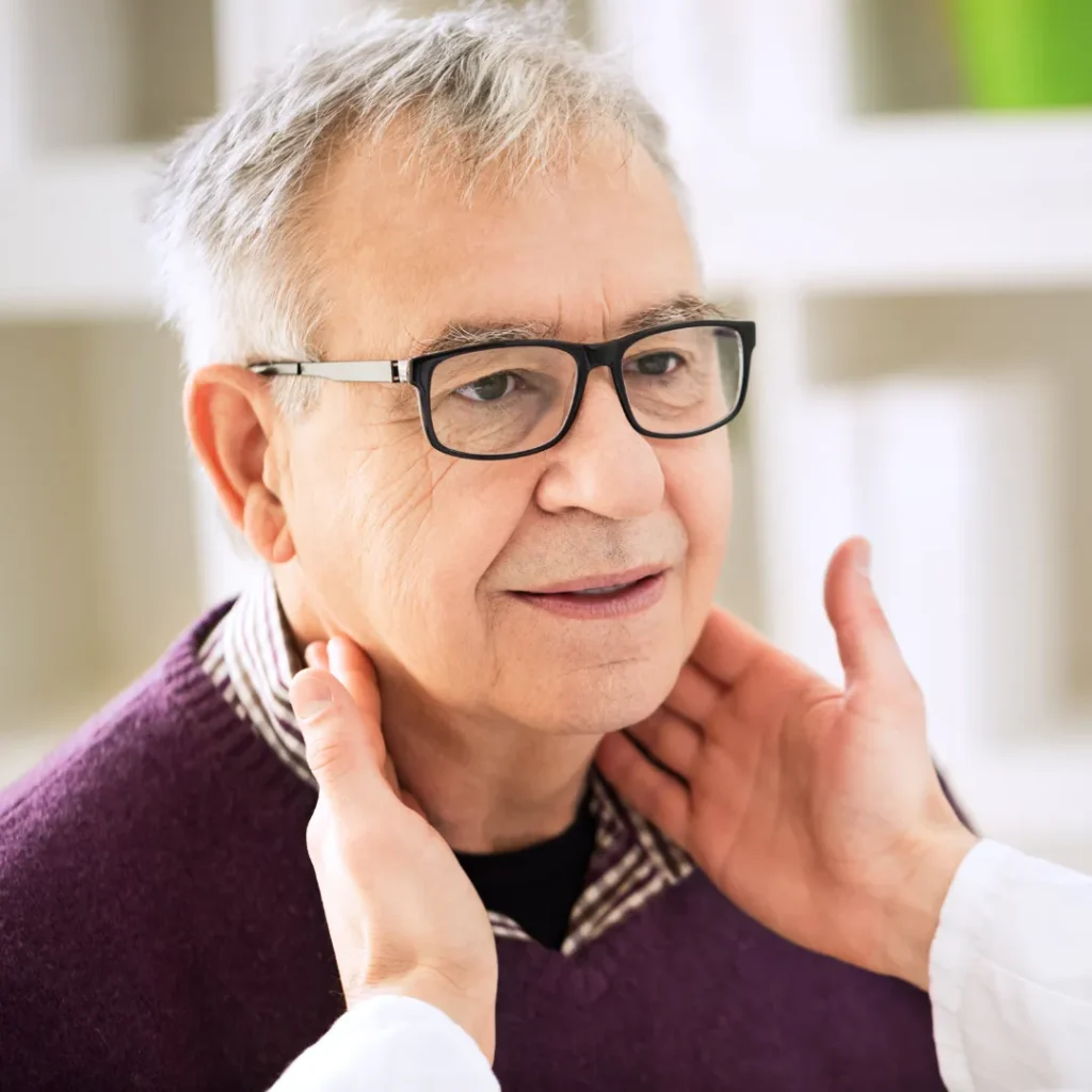 Physician checking older woman's neck area