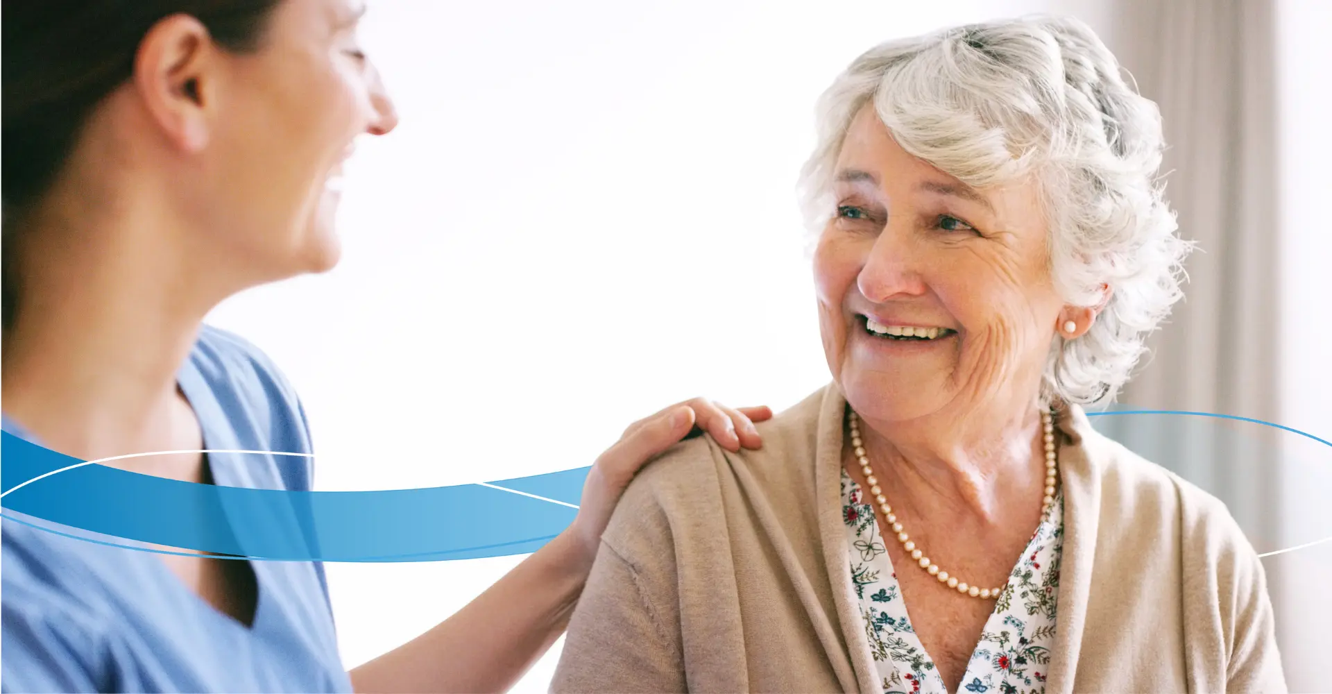 Nurse with hand on older lady who is smiling